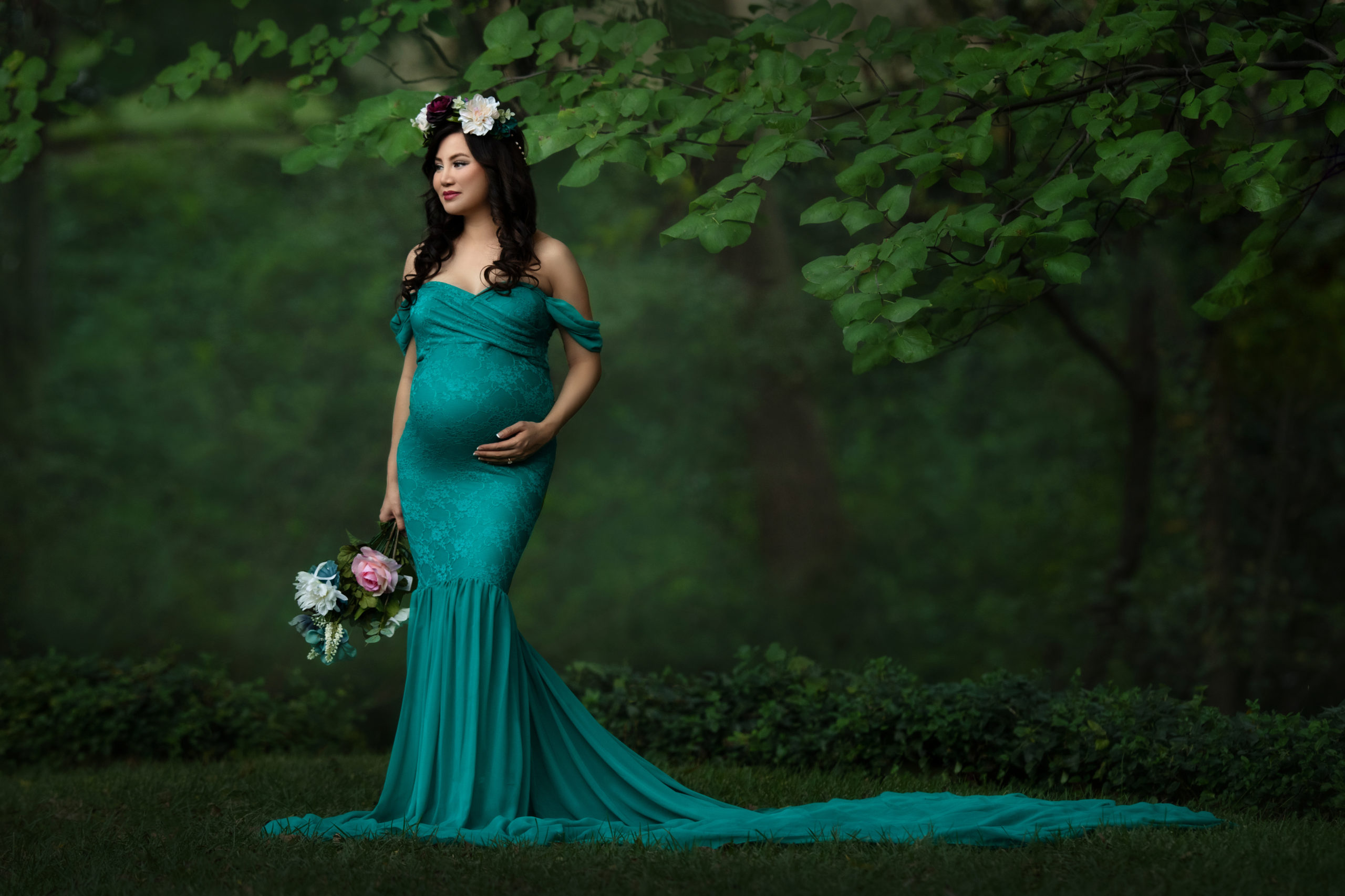 gorgeous pregnant woman in turquoise maternity gown in nature green spring session outdoors garden in dallas texas for fine art maternity photoshoot